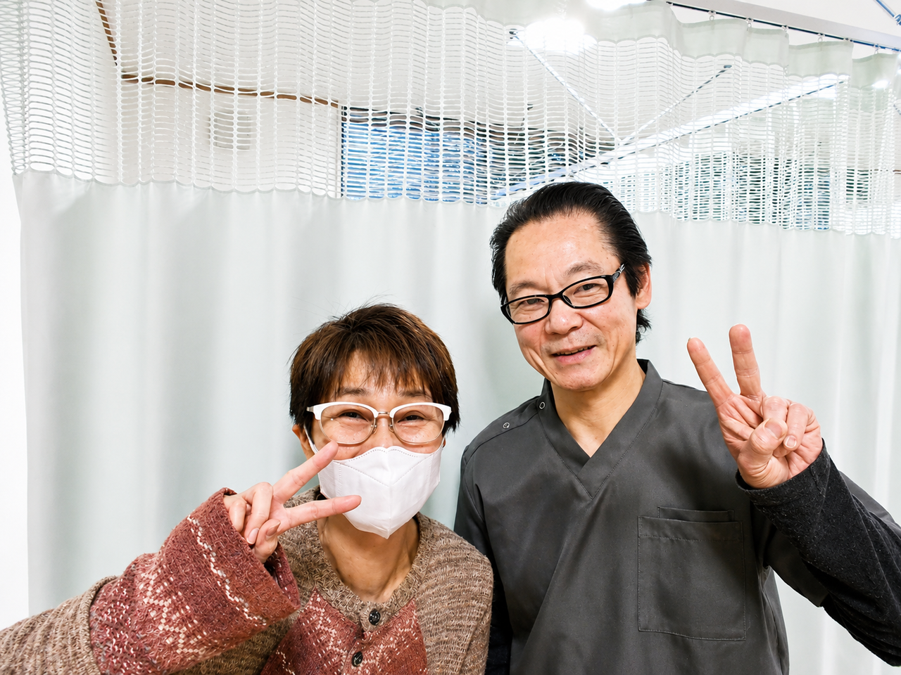 微笑み顔の院長と眼鏡をかけた女性のお客様