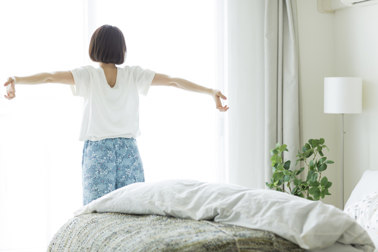 窓から外を見てリラックスしている女性