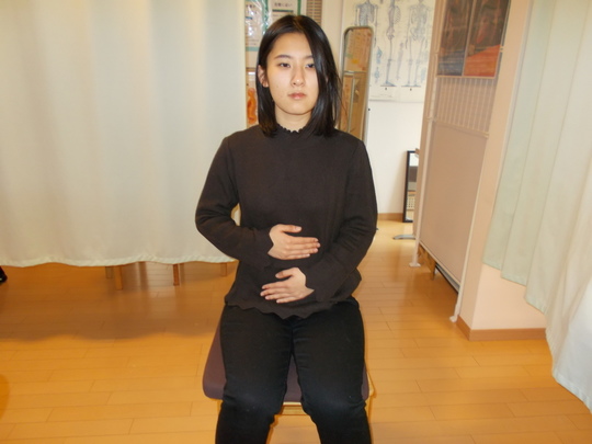 反り腰のチェック法の指導を受けている女性