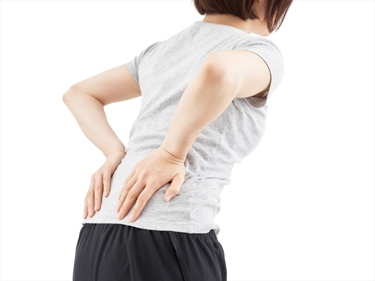 両手で腰を押さえている女性の後ろ姿